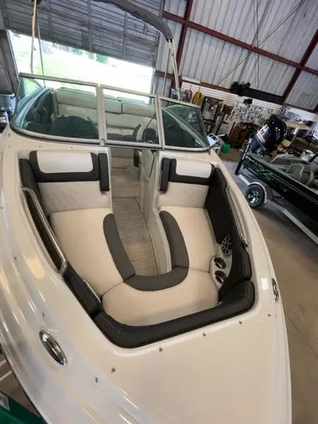 Slide: The Image of 2023 Crownline 200 SS boat interior with cushioned seating in a showroom. - 7