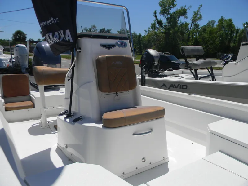 Slide: The Image of 2023 Avid 21 Mag boat interior with seating and console, featuring Yamaha engine. - 12