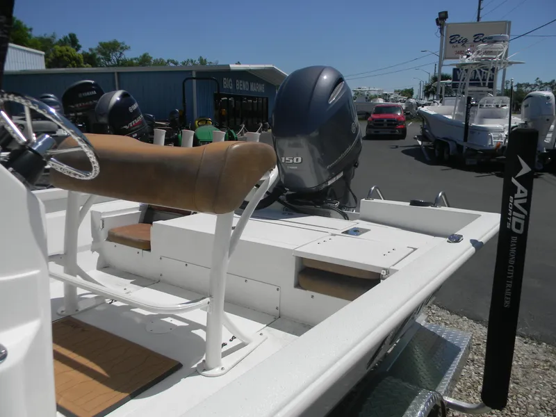 Slide: The Image of 2023 Avid 21 Mag boat with Yamaha 150 engine, parked at a marina. - 15