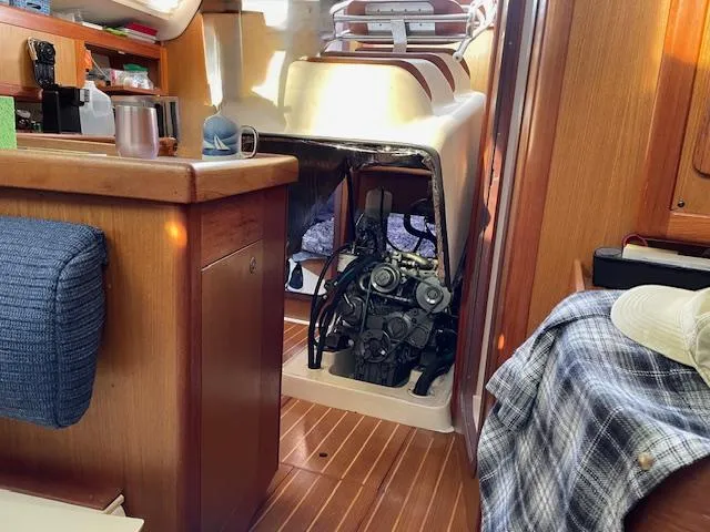 Slide: The Image of Interior of a 1999 Hunter 380 sailboat showing engine compartment and wooden cabinetry. - 17