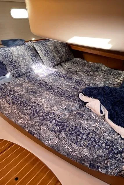 Slide: The Image of Cozy cabin interior of 1999 Hunter 380 sailboat with patterned bedding. - 19