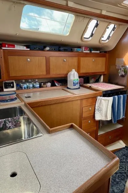 Slide: The Image of Interior of 1999 Hunter 380 sailboat kitchen with wooden cabinets and modern amenities. - 23