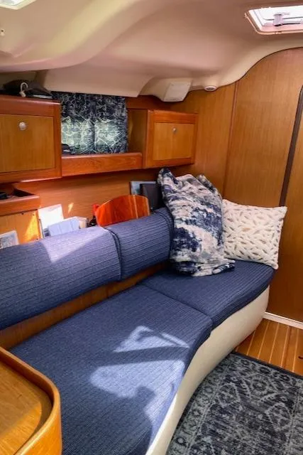 Slide: The Image of Interior of a 1999 Hunter 380 sailboat with cozy seating and wooden cabinetry. - 24