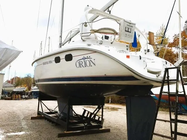 Slide: The Image of Hunter 380 sailboat from 1999 on dry dock, named "Orion," with visible ladder and equipment. - 35