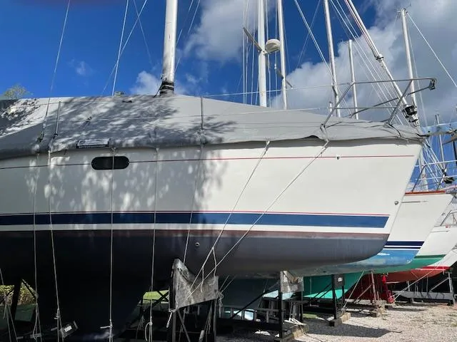 Slide: The Image of 1999 Hunter 380 sailboat on stands under a clear blue sky. - 47