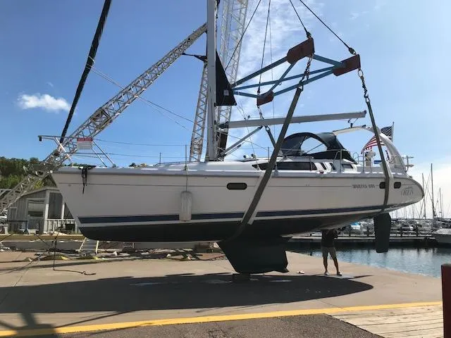 Slide: The Image of 1999 Hunter 380 sailboat being lifted by crane at marina. - 6