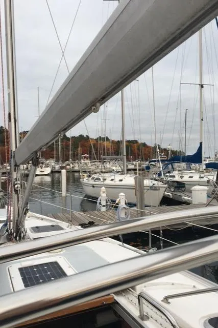 Slide: The Image of Sailboats docked at a marina, featuring a 1999 Hunter 380 sailboat in the foreground. - 9