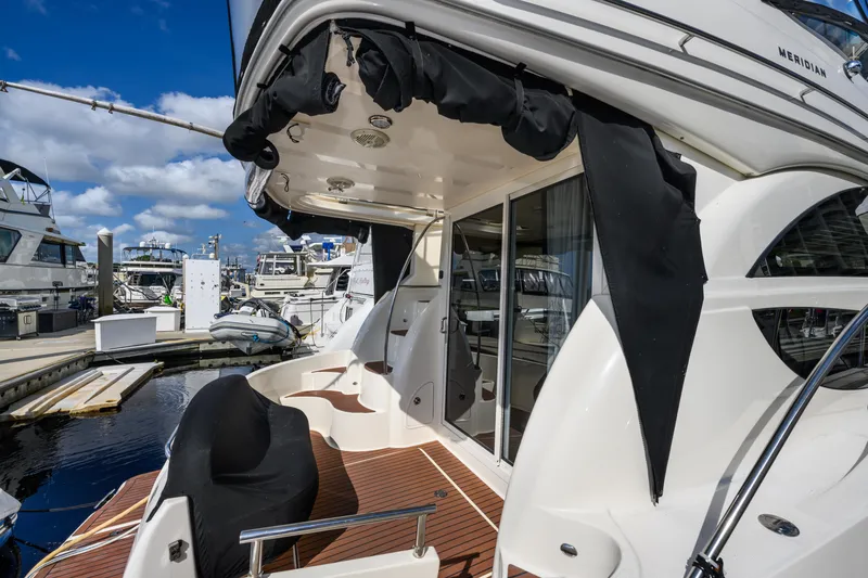 Slide: The Image of 2008 Meridian 341 Sedan yacht docked at marina, featuring sleek design and spacious deck area. - 13