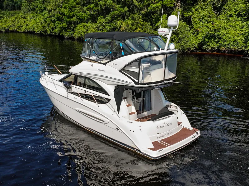 Slide: The Image of 2008 Meridian 341 Sedan yacht cruising on a serene river, surrounded by lush greenery. - 2