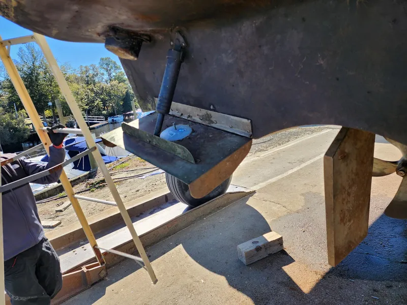 Slide: The Image of 2008 Meridian 341 Sedan boat under maintenance, showing hull and propeller area. - 43