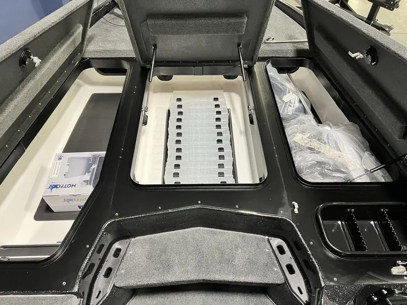 Slide: The Image of 2025 Skeeter ZXR20 boat storage compartments with open lids and organized interior layout. - 10