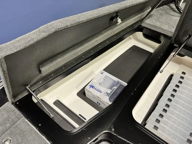 Slide: The Image of 2025 Skeeter ZXR20 boat storage compartment with organized interior and Hot Foot throttle box. - 12