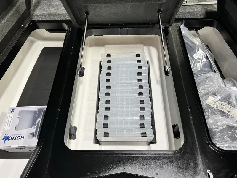 Slide: The Image of 2025 Skeeter ZXR20 storage compartment with organized tackle trays and accessories. - 14