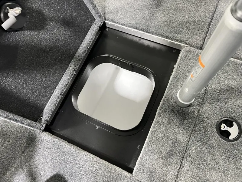 Slide: The Image of Open storage compartment on 2025 Skeeter ZXR20 boat with gray carpeted flooring. - 23