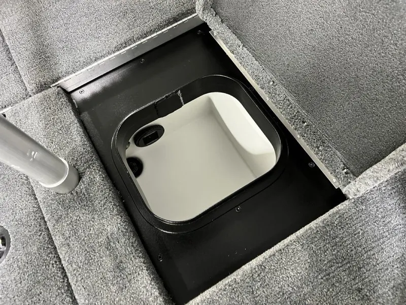 Slide: The Image of 2025 Skeeter ZXR20 boat storage compartment with gray carpeted interior. - 24