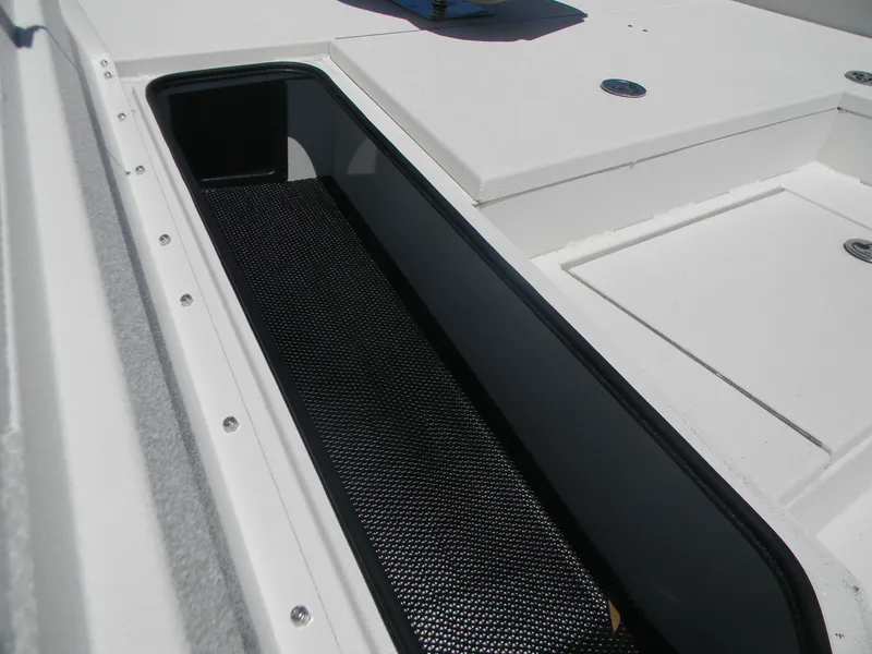 Slide: The Image of 2024 Avid 21 Mag boat storage compartment with black lining and white exterior. - 10