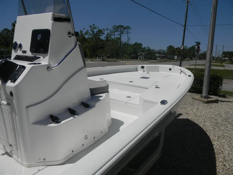 Slide: The Image of 2024 Avid 21 Mag boat, white deck, console view, parked on gravel. - 4