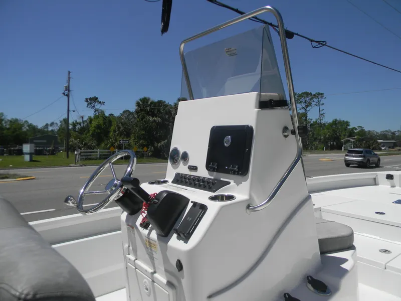 Slide: The Image of 2024 Avid 21 Mag boat console with steering wheel and controls, set against a clear sky. - 5