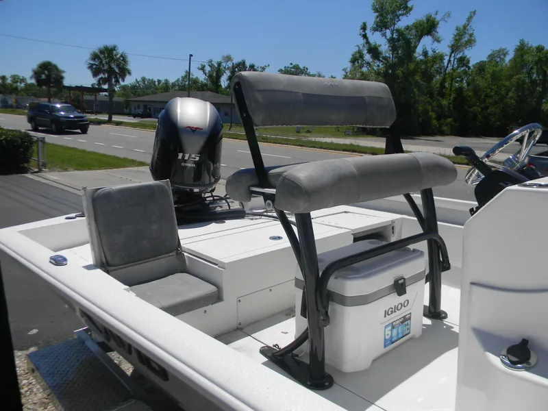 Slide: The Image of 2024 Avid 21 Mag boat with seating and outboard motor, parked near a road. - 6