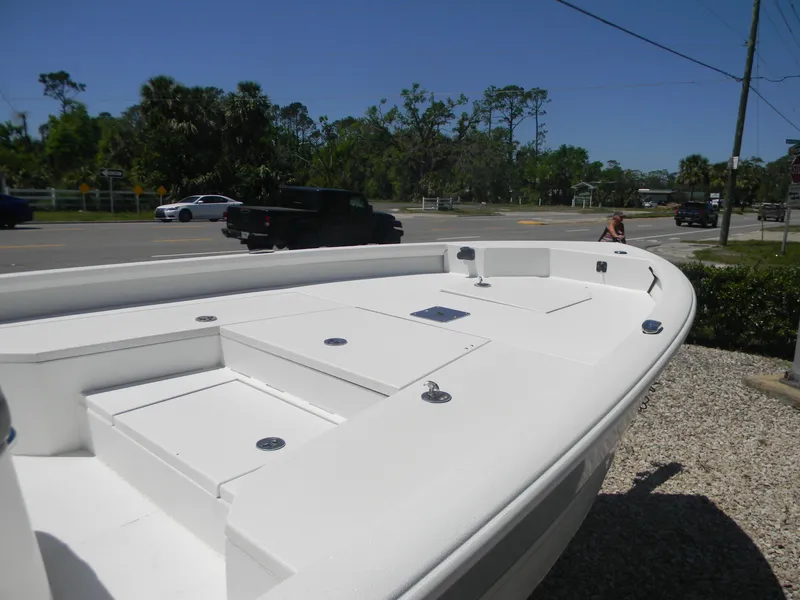Slide: The Image of 2024 Avid 21 Mag boat with spacious deck, parked near a road. - 7
