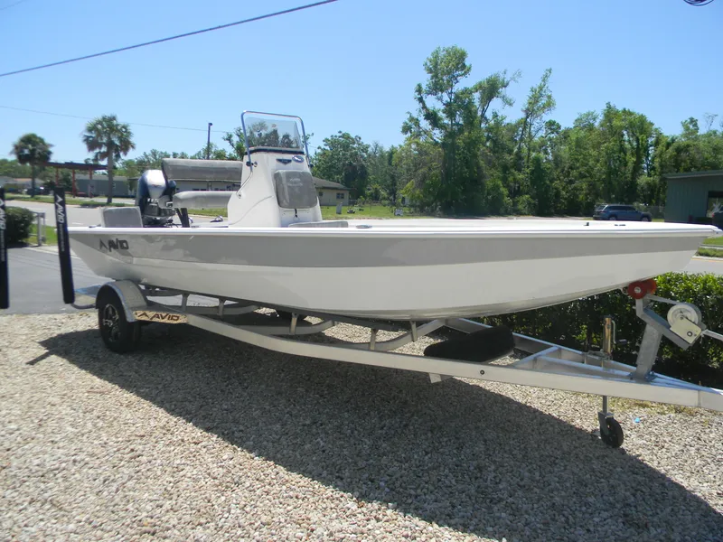 Slide: The Image of 2024 Avid 21 Mag boat on trailer, parked outdoors on gravel. - 8