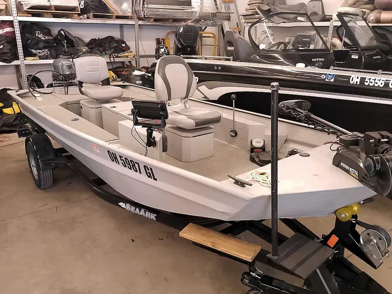 Slide: The Image of 2024 SeaArk 1652 Crappie fishing boat in a garage, featuring comfortable seating and modern equipment. - 1