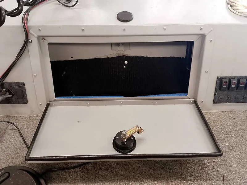 Slide: The Image of 2024 SeaArk 1652 Crappie boat storage compartment with open hatch and control panel. - 19