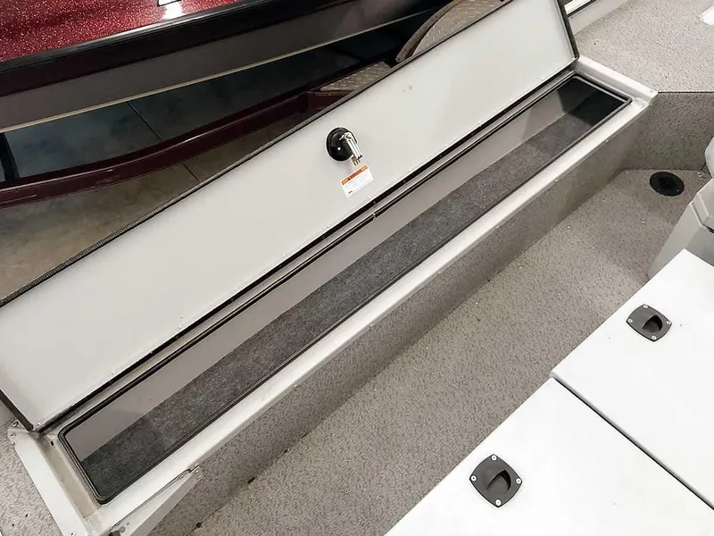Slide: The Image of 2024 SeaArk 1652 Crappie boat storage compartment, open and empty, with secure latch. - 22