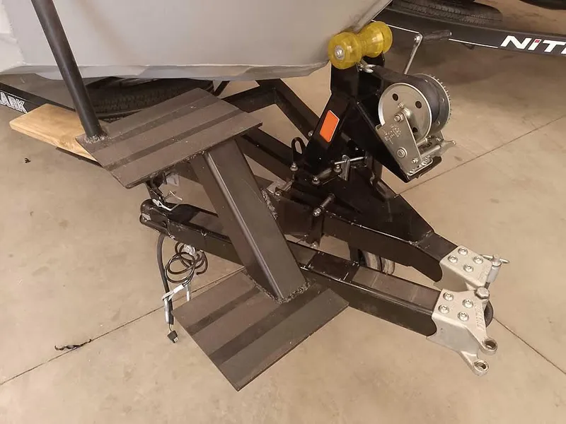 Slide: The Image of 2024 SeaArk 1652 Crappie boat trailer hitch and winch system in a garage. - 4