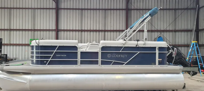 Slide: The Image of 2022 Godfrey Sweetwater SW2086 pontoon boat in a warehouse setting. - 1