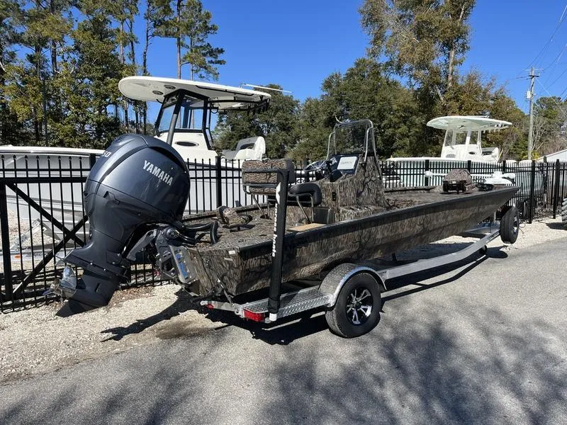 Slide: The Image of 2025 Xpress H210B boat with Yamaha engine on a trailer, parked outdoors. - 2