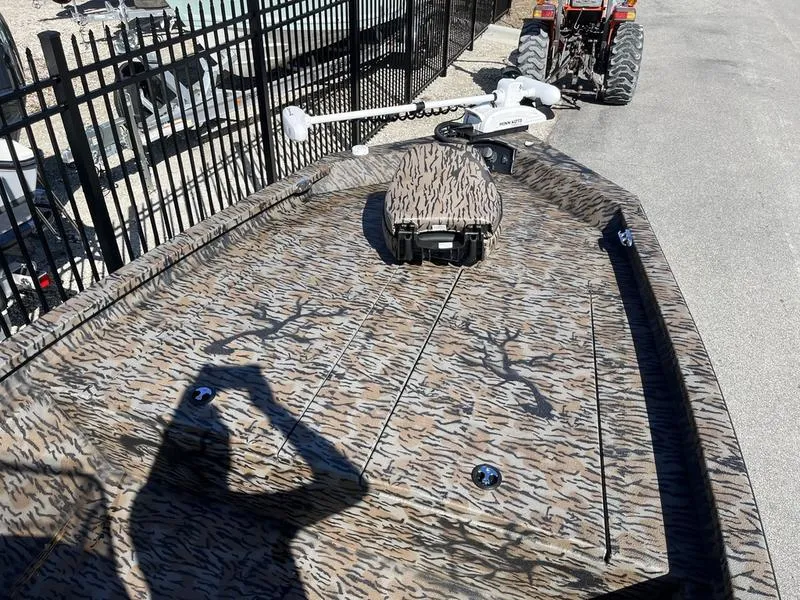 Slide: The Image of 2025 Xpress H210B boat with camouflage pattern and mounted equipment, parked near a fence. - 4