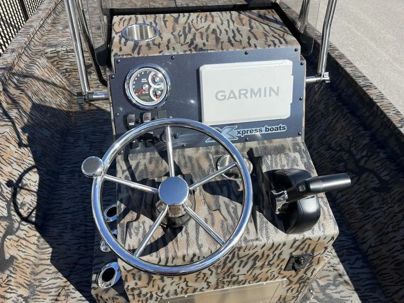 Slide: The Image of 2025 Xpress H210B boat console with Garmin display and steering wheel. - 8