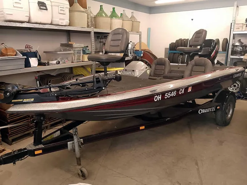 Slide: The Image of 1999 Champion 171 boat in storage, featuring seating and equipment, on a trailer. - 0