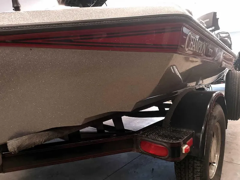 Slide: The Image of 1999 Champion 171 boat on trailer, rear view with visible taillight and branding. - 11