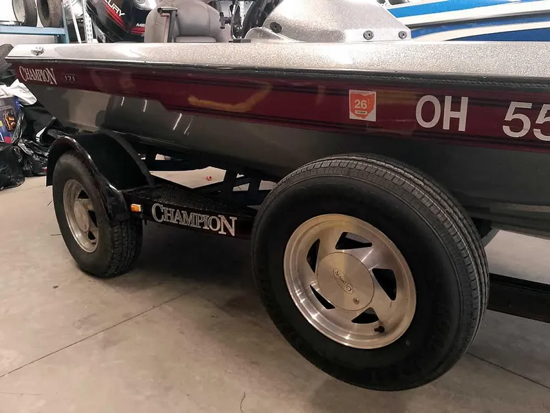 Slide: The Image of 1999 Champion 171 boat on trailer, side view with visible registration number. - 13