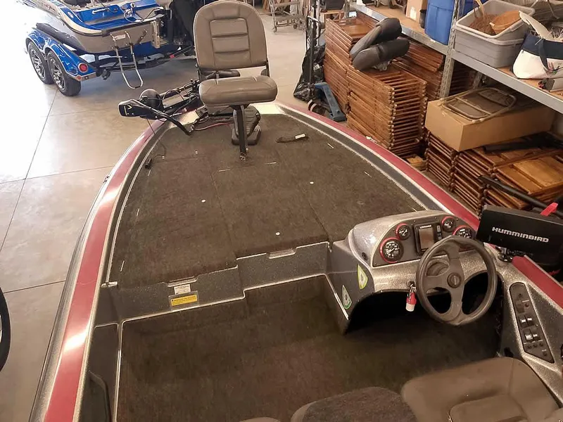 Slide: The Image of 1999 Champion 171 boat interior with steering console and seating in a garage setting. - 14