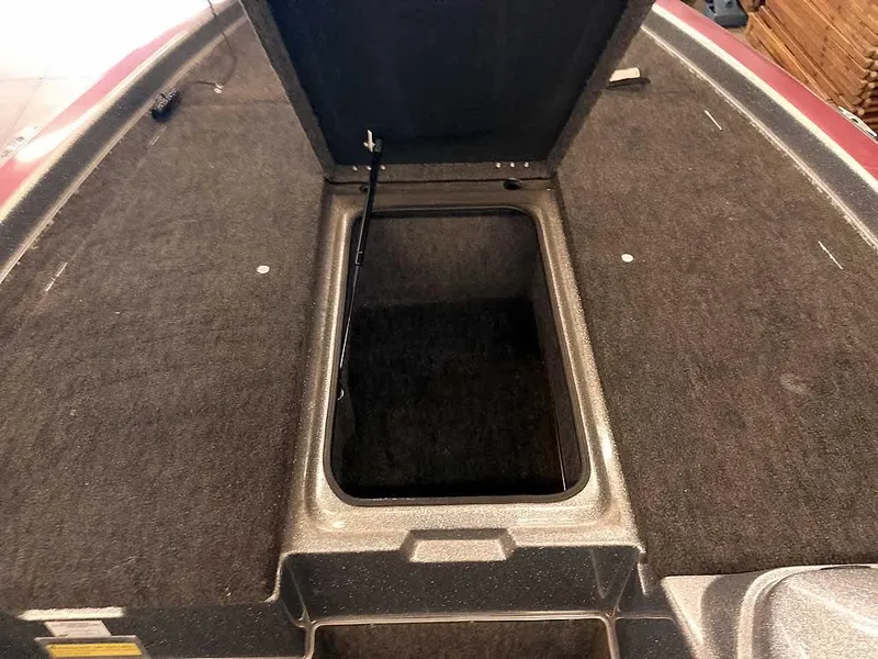 Slide: The Image of 1999 Champion 171 boat storage compartment with open hatch, carpeted interior. - 15