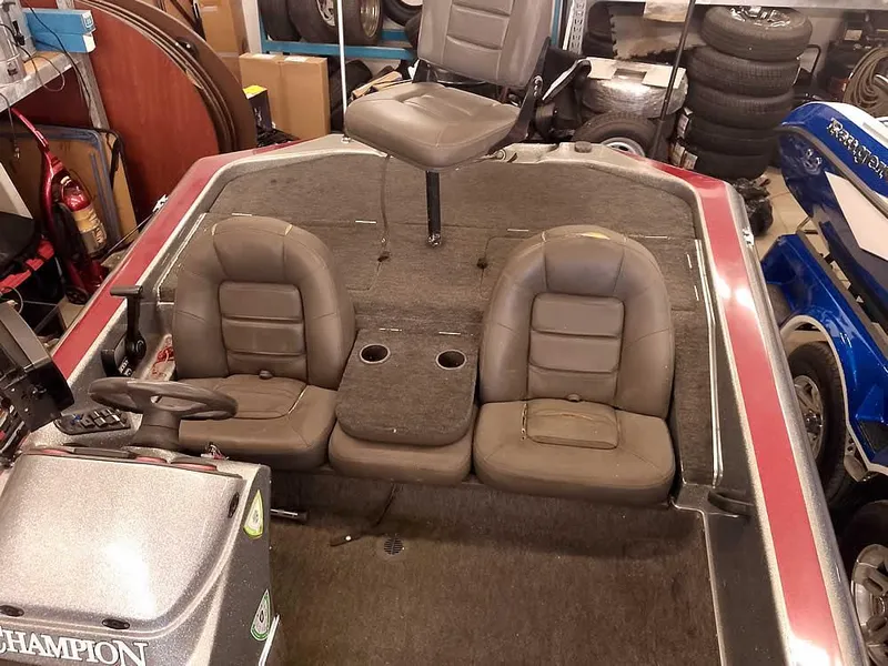 Slide: The Image of 1999 Champion 171 boat interior with three seats and steering console in a garage setting. - 21