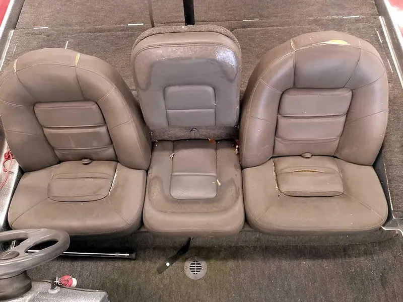 Slide: The Image of Three brown leather seats in a 1999 Champion 171 boat interior. - 22