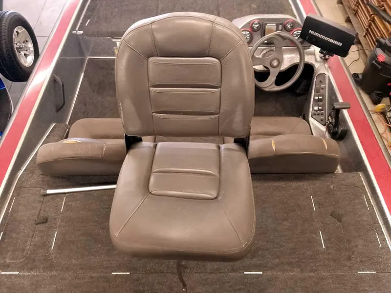 Slide: The Image of Brown leather seat in a 1999 Champion 171 boat interior, featuring steering wheel and controls. - 28