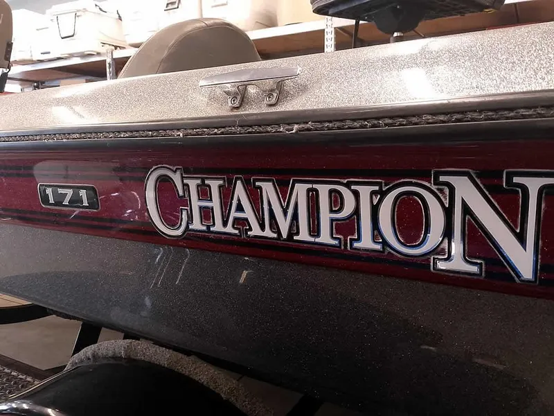 Slide: The Image of 1999 Champion 171 boat with red and silver detailing in a garage setting. - 3