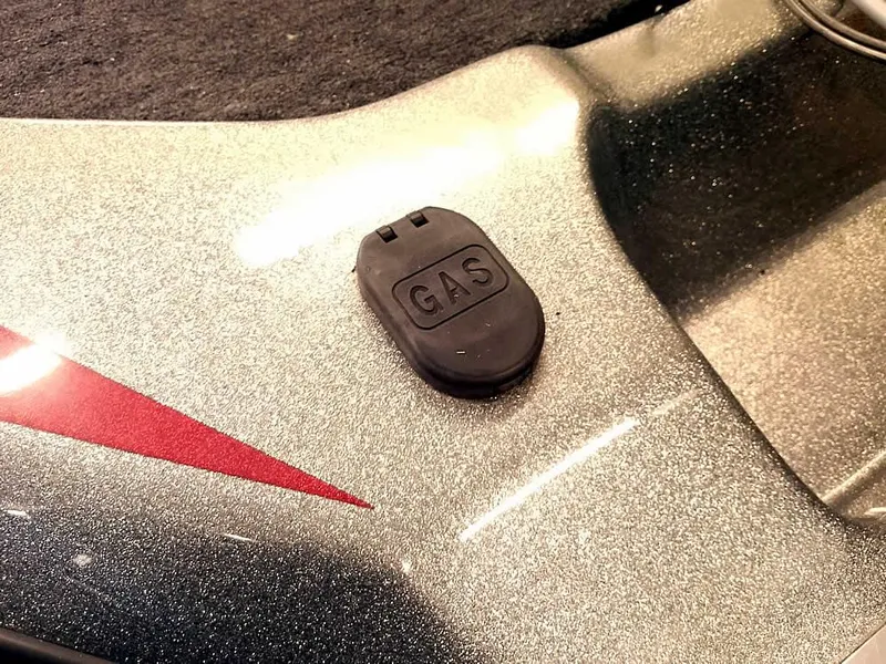 Slide: The Image of Gas cap on a 1999 Champion 171 boat with metallic finish and red accent. - 34