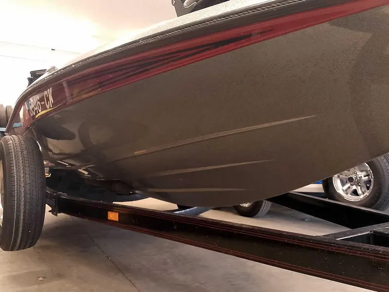Slide: The Image of 1999 Champion 171 boat on trailer, close-up view of hull and wheels. - 4