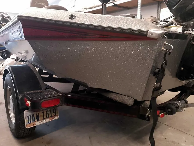 Slide: The Image of 1999 Champion 171 boat on trailer, rear view in garage setting. - 9