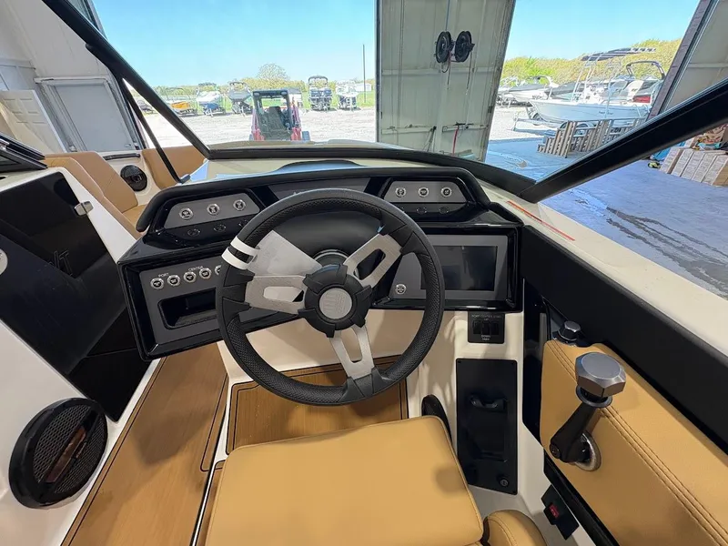 Slide: The Image of 2025 MasterCraft NXT23 boat interior with modern steering wheel and dashboard controls. - 13