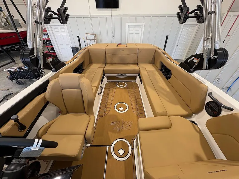 Slide: The Image of 2025 MasterCraft NXT23 boat interior with tan seating and sleek design. - 14