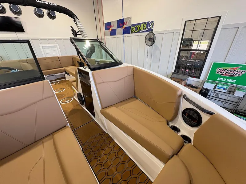 Slide: The Image of 2025 MasterCraft NXT23 boat interior with tan seating and modern design. - 17