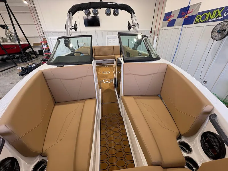 Slide: The Image of 2025 MasterCraft NXT23 boat interior with tan seating and modern design. - 18