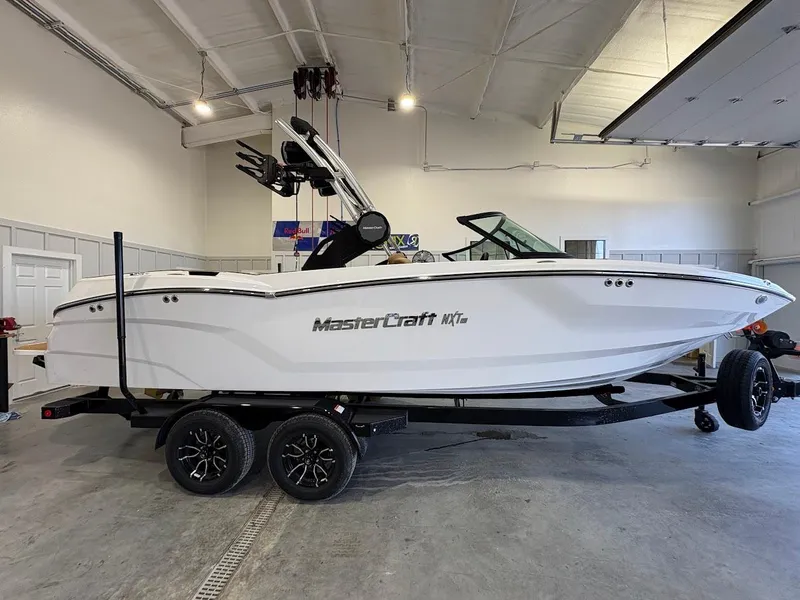 Slide: The Image of 2025 MasterCraft NXT23 boat on trailer in a garage setting. - 5
